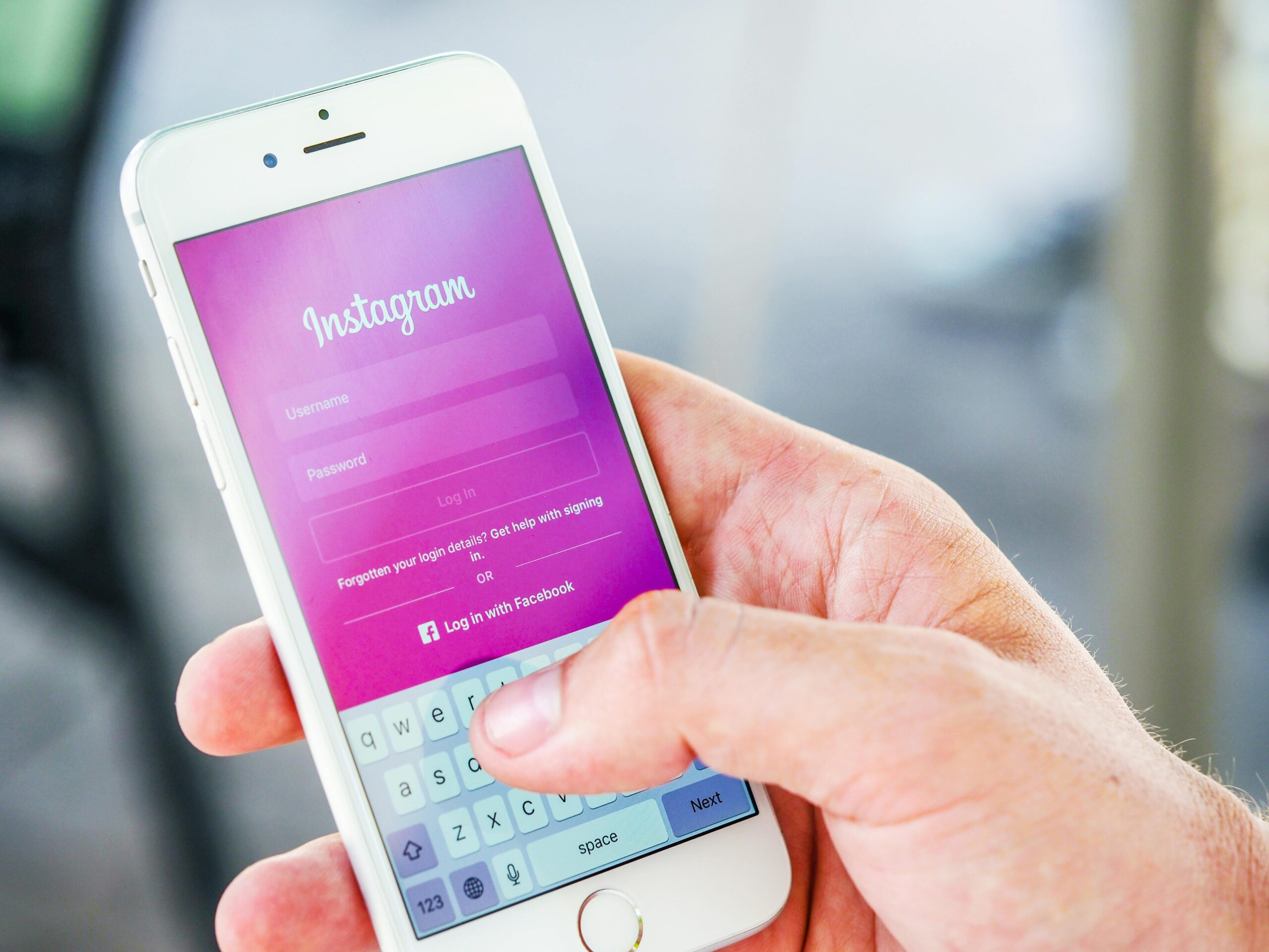 Close-up of a hand holding a smartphone displaying the Instagram login screen, highlighting mobile technology.